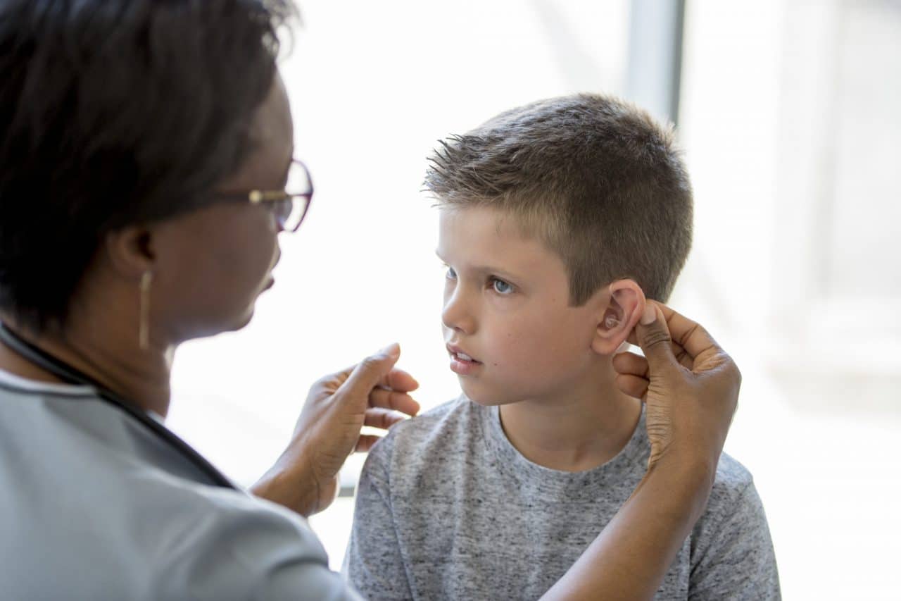 A child receiving a hearing aid fitting