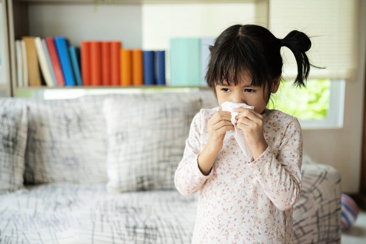 Little girl blowing her nose.