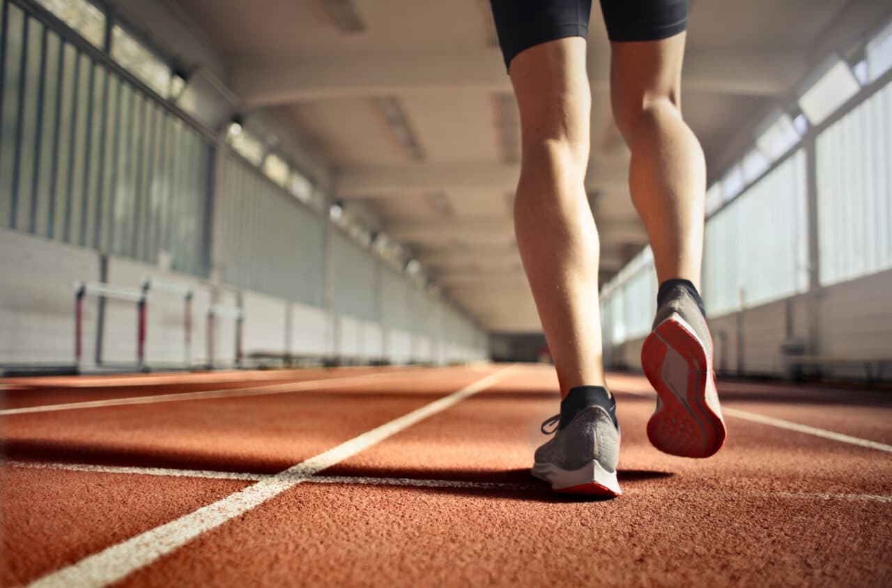 Close-up of someone's legs running on a track.