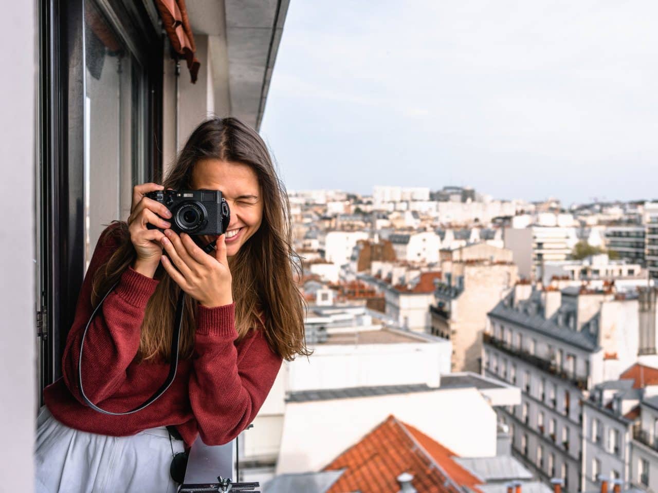 Woman taking a photo from a veranda while traveling.