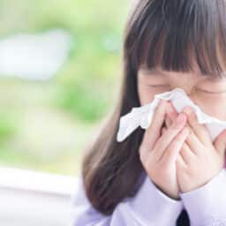Child blows nose after suffering from allergies