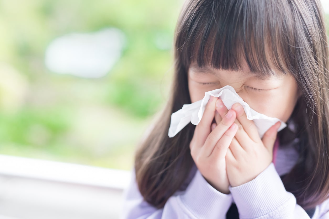 Child blows nose after suffering from allergies