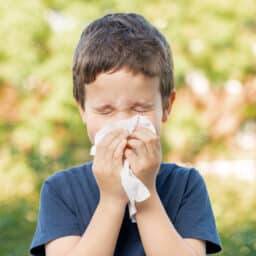 Child sneezing outdoors