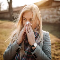 Woman with fall allergies blowing her nose