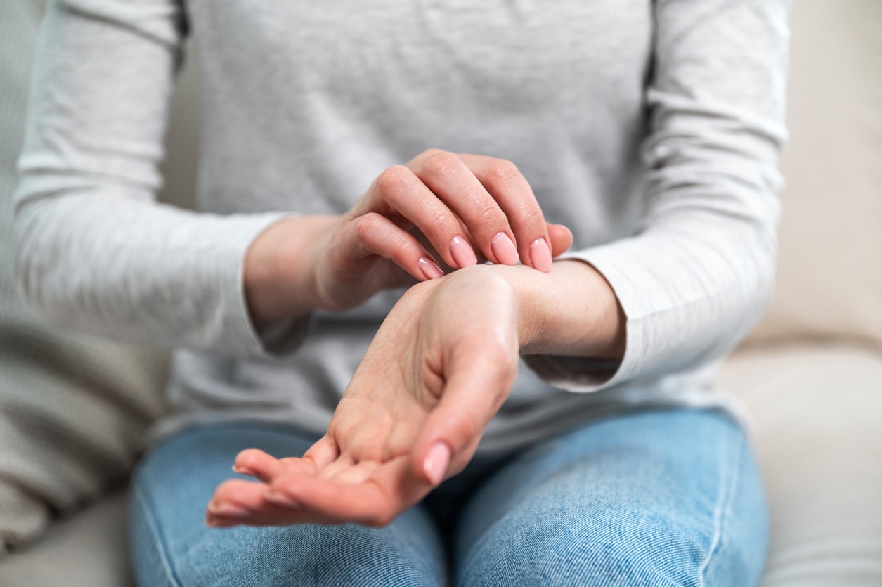 Woman scratching an itch on her wrist.